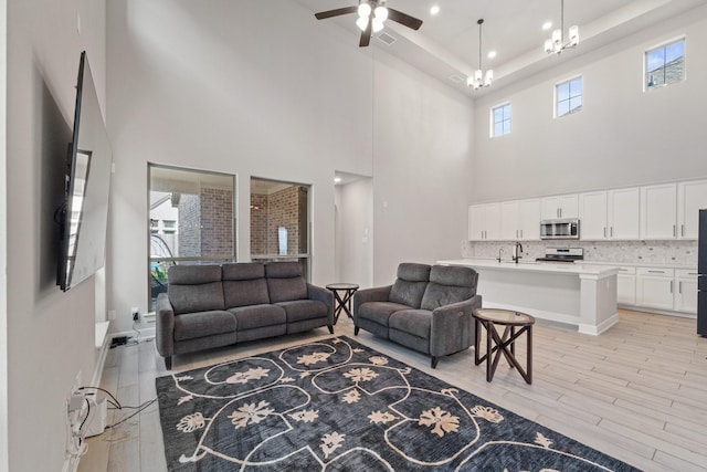 7010 Grassland Vista Ln, Katy, TX 77493 - living room featuring a towering ceiling, light wood-style flooring, and a ceiling fan