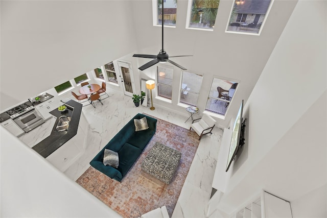 living room with marble tiled floors, french doors, a high ceiling, and ceiling fan