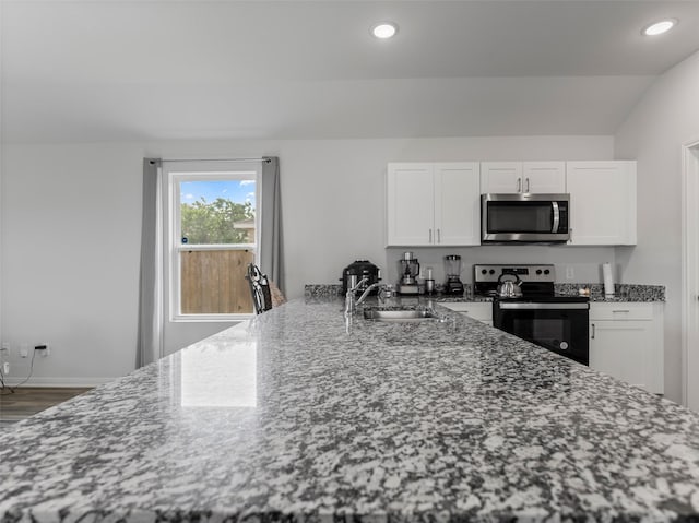 2715 Marguerite St, Bay City, TX 77414 - kitchen featuring appliances with stainless steel finishes, a sink, a peninsula, white cabinets, and recessed lighting