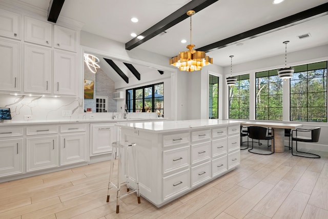 3702 Deerbend Ct, Spring, TX 77386 - kitchen featuring a chandelier, tasteful backsplash, a kitchen island, light wood-style floors, and recessed lighting