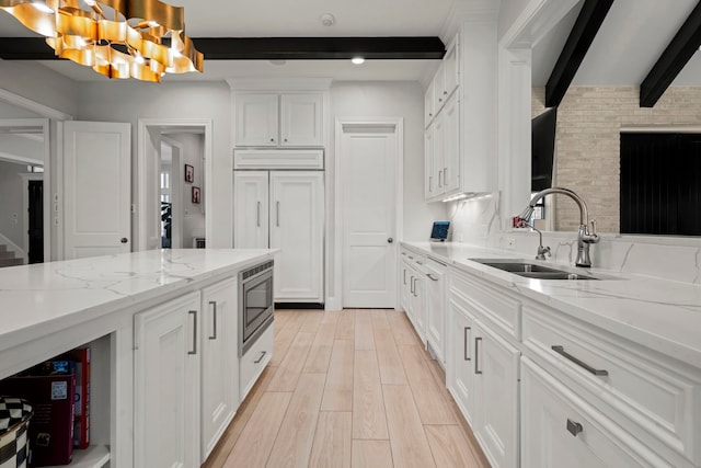 3702 Deerbend Ct, Spring, TX 77386 - kitchen with a sink, beamed ceiling, built in appliances, white cabinets, and light stone countertops