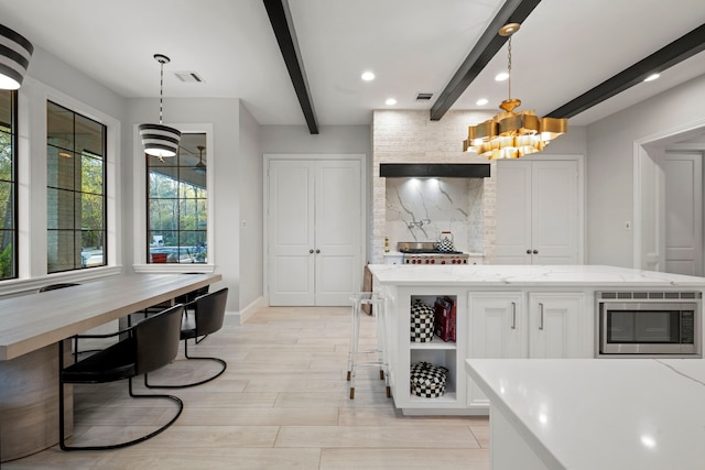 3702 Deerbend Ct, Spring, TX 77386 - kitchen with stainless steel microwave, beam ceiling, open shelves, decorative backsplash, and white cabinets