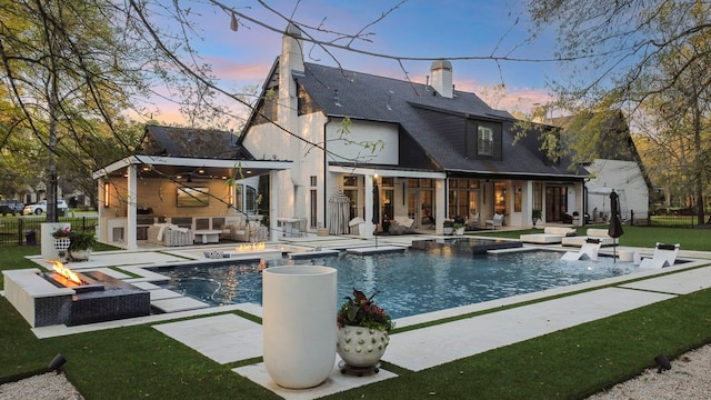 3702 Deerbend Ct, Spring, TX 77386 - back of house featuring a hot tub, an outdoor living space with a fire pit, a patio area, a chimney, and an outdoor pool