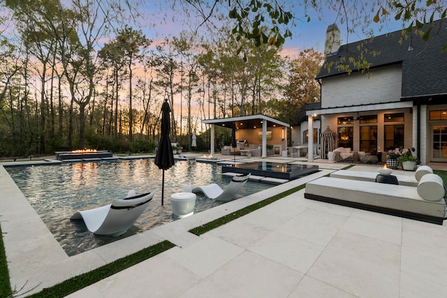 3702 Deerbend Ct, Spring, TX 77386 - pool at dusk with outdoor lounge area, a patio area, and a pool with connected hot tub