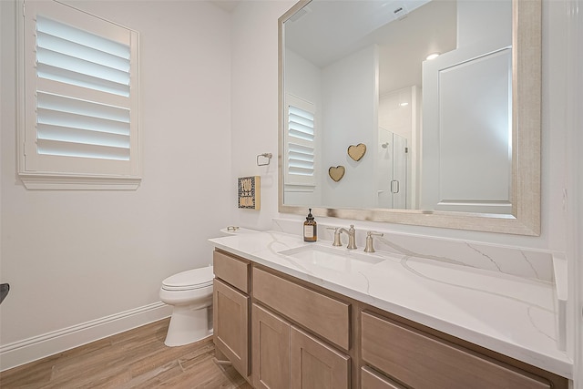 10615 Painted Crescent Ct, Cypress, TX 77433 - bathroom with wood finished floors, a shower stall, toilet, vanity, and baseboards