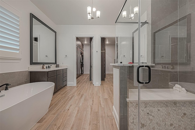 10615 Painted Crescent Ct, Cypress, TX 77433 - full bathroom with a stall shower, a freestanding tub, vanity, wood finished floors, and a chandelier