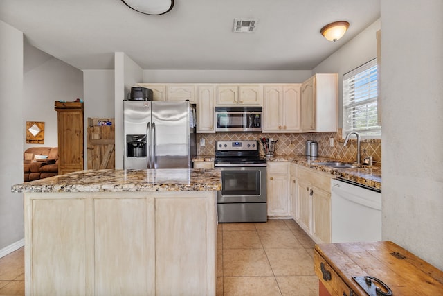 11664 Fm 92, Silsbee, TX 77656 - kitchen with appliances with stainless steel finishes, a sink, tasteful backsplash, light tile patterned flooring, and light stone countertops