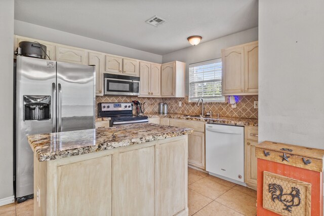 11664 Fm 92, Silsbee, TX 77656 - kitchen featuring appliances with stainless steel finishes, a sink, backsplash, light stone countertops, and light tile patterned floors