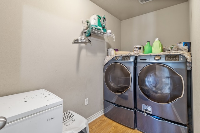 11664 Fm 92, Silsbee, TX 77656 - clothes washing area with washer and clothes dryer, wood finished floors, and baseboards