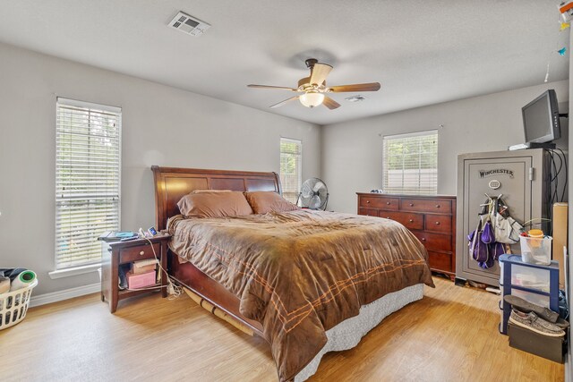 11664 Fm 92, Silsbee, TX 77656 - bedroom with light wood-style flooring, a ceiling fan, and baseboards