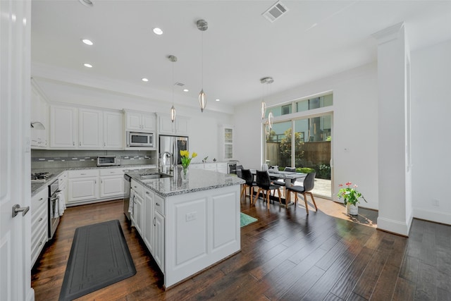 11015 Ayrshire Park Ln, Houston, TX 77043 - kitchen with stainless steel appliances, a sink, white cabinetry, light stone countertops, and a kitchen island with sink
