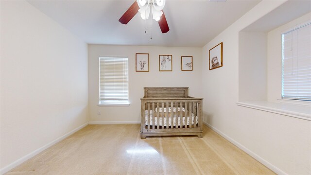 2702 Skyview Moon Dr, Houston, TX 77047 - bedroom with carpet floors, baseboards, a nursery area, and a ceiling fan