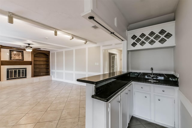 14922 Walters Rd, Houston, TX 77068 - kitchen with dark countertops, a ceiling fan, a peninsula, and built in features