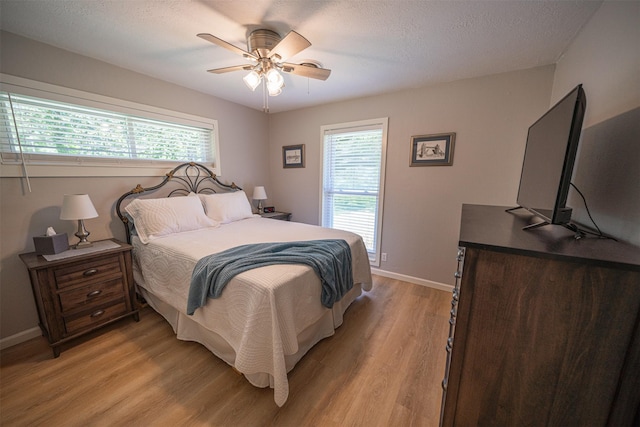 1191 Barnum Blvd, Corrigan, TX 75939 - bedroom featuring light wood finished floors, multiple windows, and baseboards