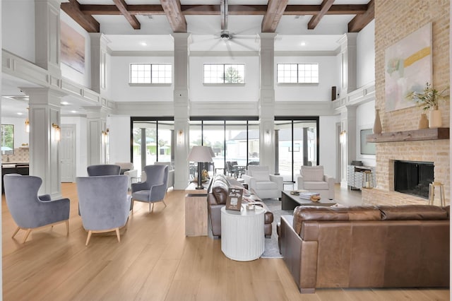 31766 Chapel Rock Ln, Spring, TX 77386 - living room with ornate columns, beam ceiling, a high ceiling, ceiling fan, and light wood-style flooring