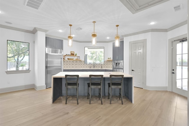 31766 Chapel Rock Ln, Spring, TX 77386 - kitchen featuring built in fridge, light countertops, tasteful backsplash, ornamental molding, and gray cabinets