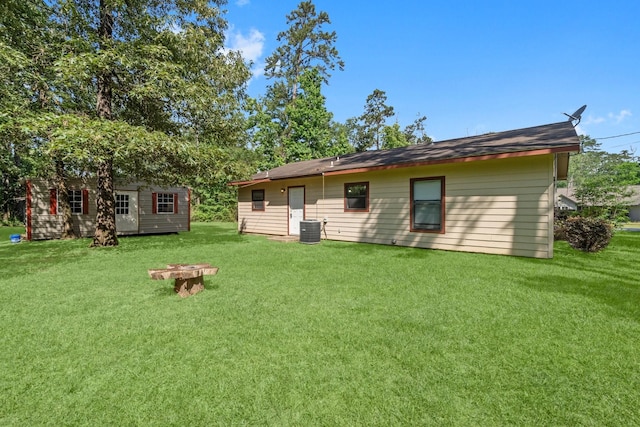 185 Rustic Way, Livingston, TX 77351 - rear view of property with central air condition unit, a lawn, and an outbuilding