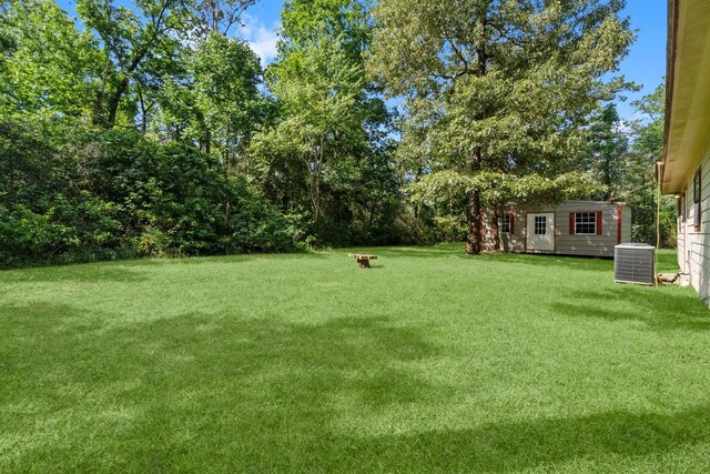 185 Rustic Way, Livingston, TX 77351 - view of green lawn featuring an outbuilding and central AC