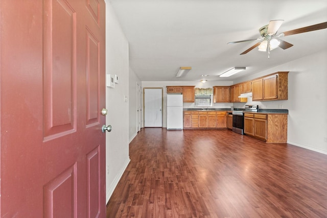 185 Rustic Way, Livingston, TX 77351 - kitchen with freestanding refrigerator, stainless steel electric range oven, dark wood-type flooring, dark countertops, and brown cabinetry