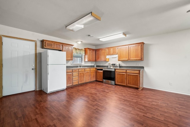 185 Rustic Way, Livingston, TX 77351 - kitchen featuring freestanding refrigerator, stainless steel electric range, under cabinet range hood, dark wood-style flooring, and baseboards