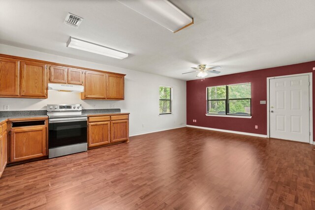 185 Rustic Way, Livingston, TX 77351 - kitchen with stainless steel electric range, under cabinet range hood, wood finished floors, a ceiling fan, and brown cabinetry