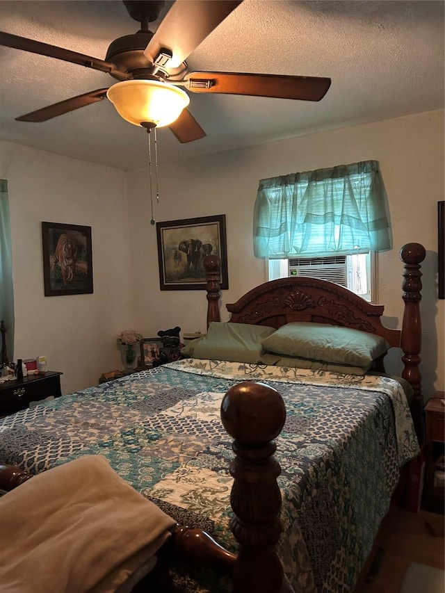 26735 Saddle Rock Ln, New Caney, TX 77357 - bedroom with cooling unit, a ceiling fan, a textured ceiling, and wood finished floors