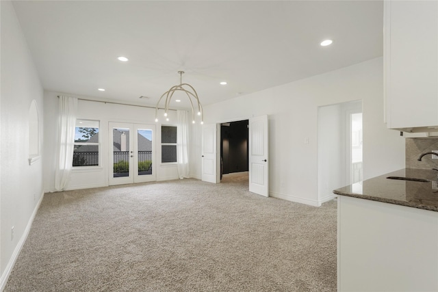 18011 Stari Most Ln, Houston, TX 77044 - unfurnished living room featuring a sink, light carpet, baseboards, recessed lighting, and french doors