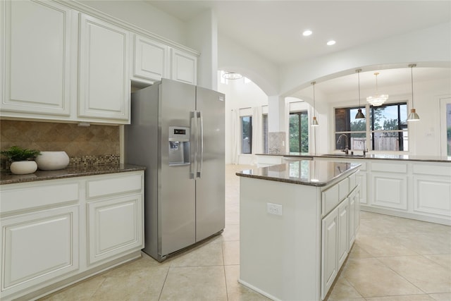 18011 Stari Most Ln, Houston, TX 77044 - kitchen featuring stainless steel fridge with ice dispenser, a sink, backsplash, a center island, and dark stone counters