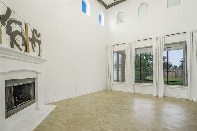 18011 Stari Most Ln, Houston, TX 77044 - unfurnished living room featuring a high ceiling, a fireplace with raised hearth, and tile patterned flooring