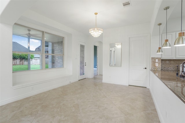 18011 Stari Most Ln, Houston, TX 77044 - unfurnished dining area featuring arched walkways, a chandelier, light tile patterned floors, and baseboards