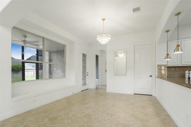 18011 Stari Most Ln, Houston, TX 77044 - unfurnished dining area featuring arched walkways, ceiling fan, light tile patterned flooring, and baseboards