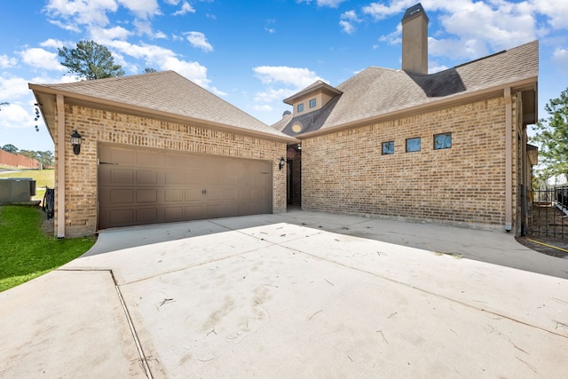 32 Evangeline Blvd, Conroe, TX 77304 - view of front of property with brick siding, a shingled roof, concrete driveway, a garage, and a chimney