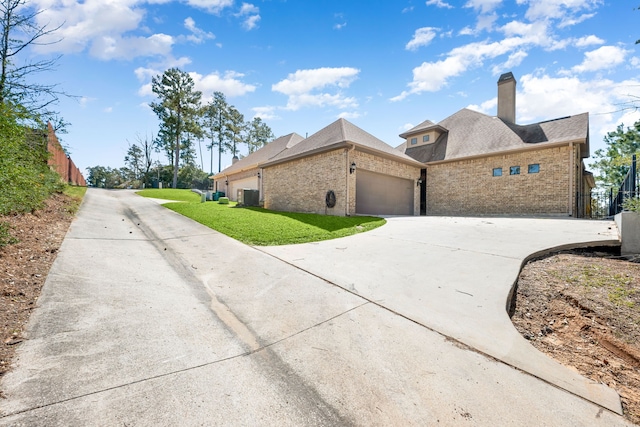 32 Evangeline Blvd, Conroe, TX 77304 - view of side of property with brick siding, an attached garage, cooling unit, and concrete driveway