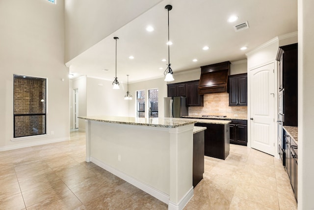 32 Evangeline Blvd, Conroe, TX 77304 - kitchen featuring a kitchen island, freestanding refrigerator, ornamental molding, backsplash, and custom exhaust hood