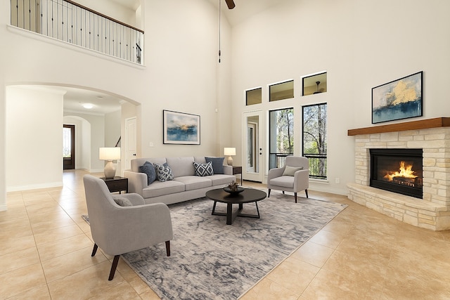 32 Evangeline Blvd, Conroe, TX 77304 - living room featuring tile patterned floors, a fireplace, a towering ceiling, arched walkways, and baseboards