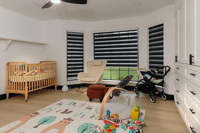 15232 Saddlewood Dr, Conroe, TX 77384 - bedroom with light wood-type flooring, ceiling fan, and a crib