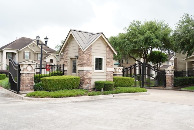 16019 Summerville Lake Dr, Tomball, TX 77377 - view of front of home with stone siding, a gate, and fence