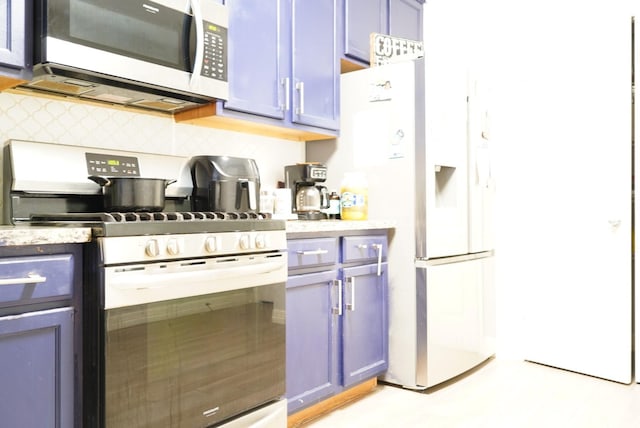 16019 Summerville Lake Dr, Tomball, TX 77377 - kitchen with stainless steel appliances, blue cabinets, and light stone countertops