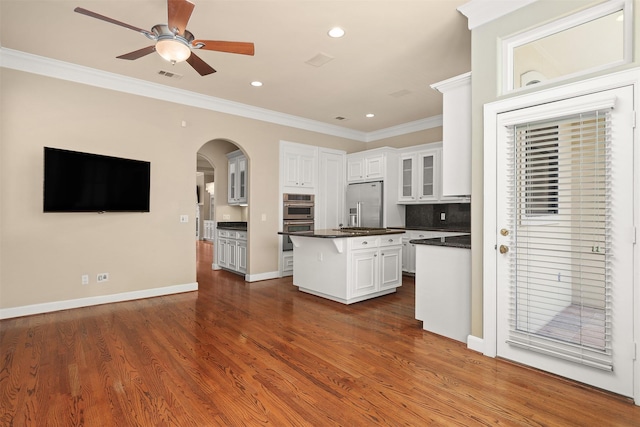 2019 Driscoll St Unit B, Houston, TX 77019 - kitchen with arched walkways, crown molding, a ceiling fan, a center island, and dark countertops
