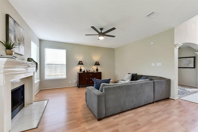 17006 Valley Palms Dr, Spring, TX 77379 - living area featuring a ceiling fan, light wood-style flooring, a tile fireplace, decorative columns, and baseboards