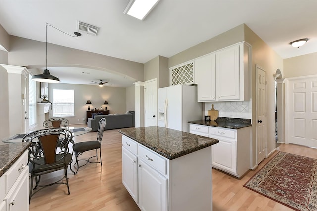 17006 Valley Palms Dr, Spring, TX 77379 - kitchen with white fridge with ice dispenser, ceiling fan, light wood finished floors, decorative columns, and white cabinets