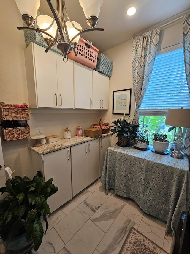 1013 Goose Creek St, Webster, TX 77598 - kitchen featuring light marble finish floors, white cabinetry, a chandelier, recessed lighting, and light stone countertops