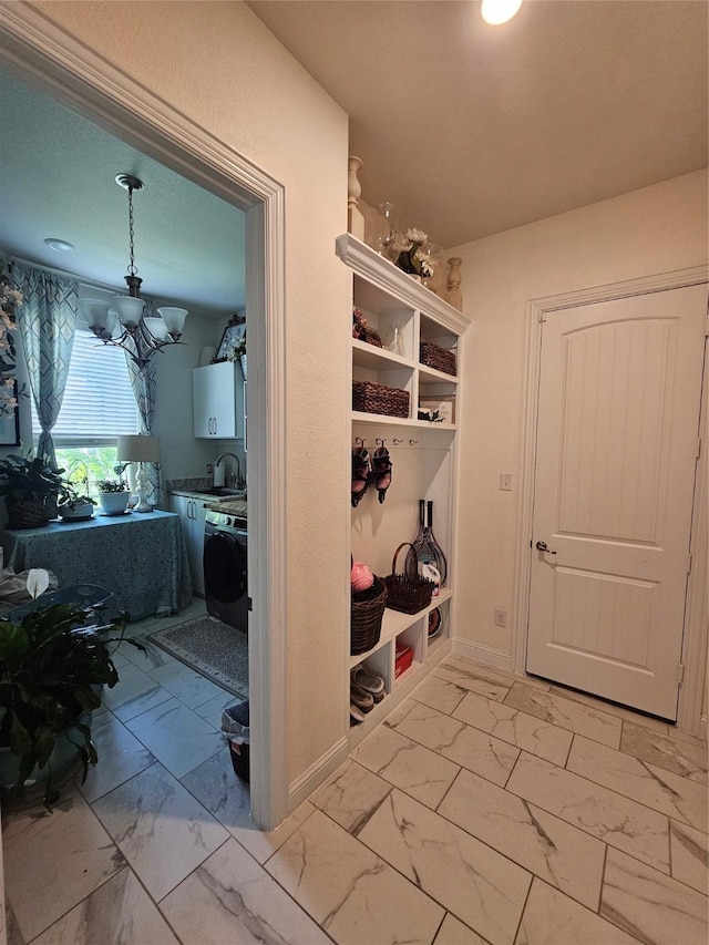 1013 Goose Creek St, Webster, TX 77598 - mudroom with light marble finish flooring, a chandelier, and washer / clothes dryer