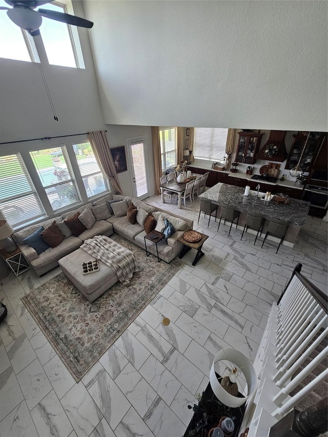 1013 Goose Creek St, Webster, TX 77598 - living area featuring marble finish flooring, ceiling fan, and a towering ceiling