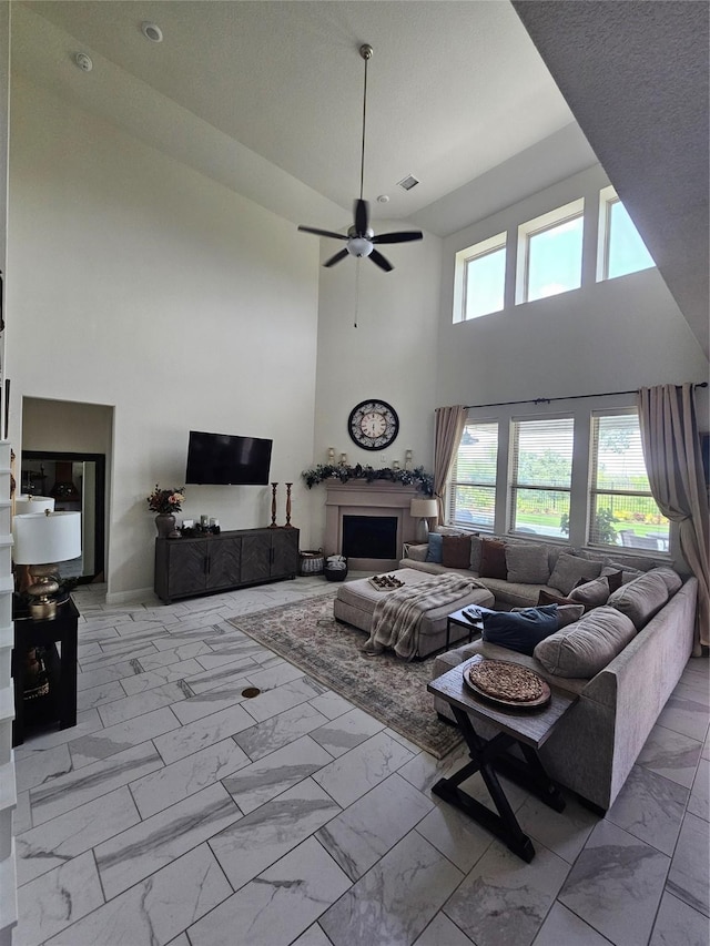 1013 Goose Creek St, Webster, TX 77598 - living room with marble finish floors, a towering ceiling, a ceiling fan, and a fireplace