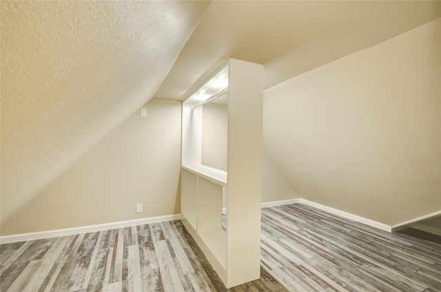 10900 Spruce Dr N, La Porte, TX 77571 - bonus room with wood finished floors, vaulted ceiling, a textured ceiling, and baseboards