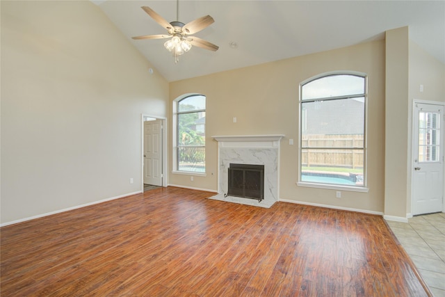 10900 Spruce Dr N, La Porte, TX 77571 - unfurnished living room with light wood-style flooring, high vaulted ceiling, plenty of natural light, a ceiling fan, and a fireplace