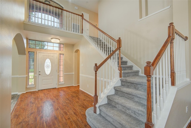 10900 Spruce Dr N, La Porte, TX 77571 - foyer entrance with arched walkways, wood finished floors, a towering ceiling, plenty of natural light, and stairway