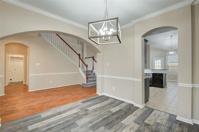 10900 Spruce Dr N, La Porte, TX 77571 - unfurnished dining area featuring light wood-style floors, a chandelier, crown molding, baseboards, and stairway
