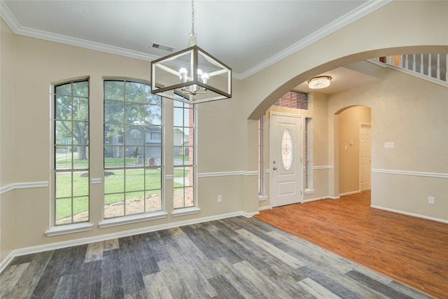 10900 Spruce Dr N, La Porte, TX 77571 - unfurnished dining area with a chandelier, wood finished floors, baseboards, crown molding, and arched walkways